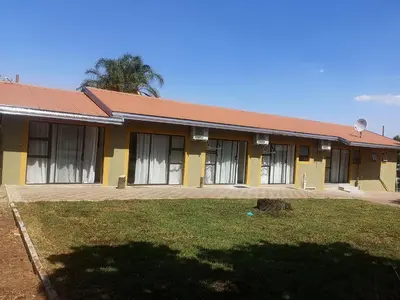 a yellow building with a red roof at Lasev Resort in Pretoria