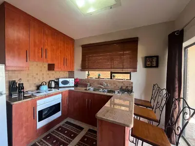 a kitchen with wooden cabinets and a counter top at Lake house retreat in Haenertsburg