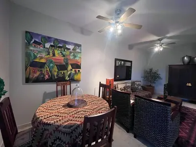 a dining room with a table and a ceiling fan at Lake house retreat in Haenertsburg