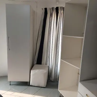a white closet with a chair and a window at 46 Charles Bed and Breakfast in Tierpoort