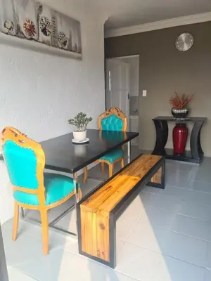 a dining room table and chairs with a wooden bench at 46 Charles Bed and Breakfast in Tierpoort