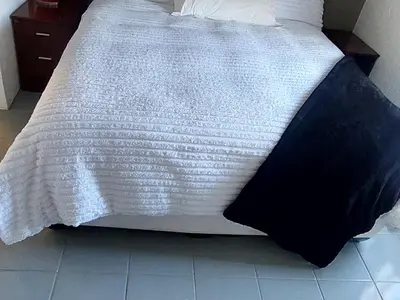 a bed with a black and white blanket on it at 46 Charles Bed and Breakfast in Tierpoort