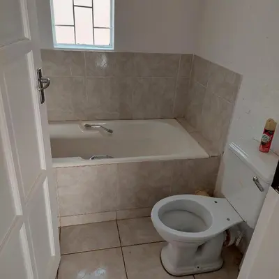 a bathroom with a white tub and a toilet at 46 Charles Bed and Breakfast in Tierpoort