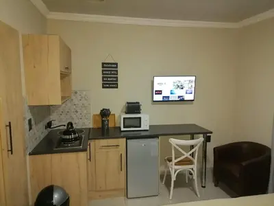 a small kitchen with a counter and a microwave at Tshepang Apartments Secunda in Secunda