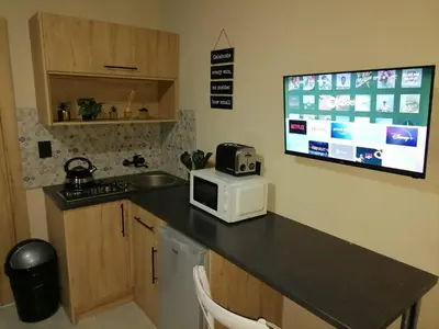 a kitchen with a counter with a microwave and a tv at Tshepang Apartments Secunda in Secunda
