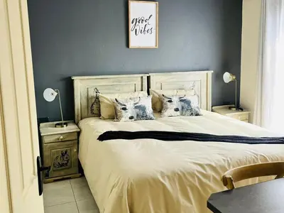 a bedroom with a large white bed with pillows at Tshepang Apartments Secunda in Secunda