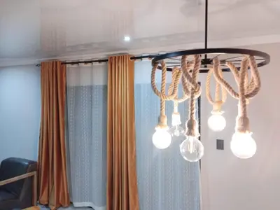 a chandelier with lights in front of a curtain at Tshepang Apartments Secunda in Secunda
