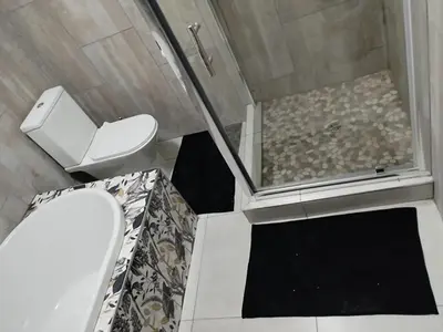 a small bathroom with a toilet and a shower at Tshepang Apartments Secunda in Secunda