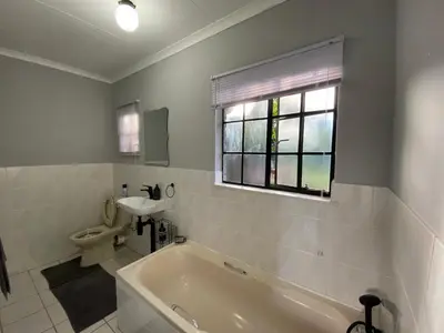 a bathroom with a tub and a toilet and a window at White River Stay in White River