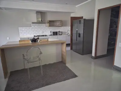 a kitchen with a chair and a counter and a refrigerator at 2 Lanner holiday home in Hartbeespoort