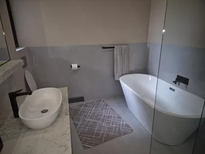 a bathroom with a tub and a toilet and a sink at 2 Lanner holiday home in Hartbeespoort