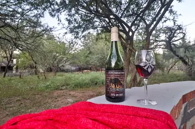 a bottle of wine and a glass on a table at P.A.P.E's RETREAT in Marloth Park