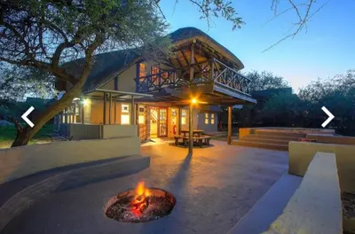 a house with a fire pit in front of it at P.A.P.E's RETREAT in Marloth Park