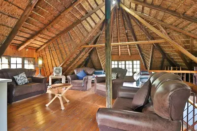 a living room with leather furniture in a attic at P.A.P.E's RETREAT in Marloth Park