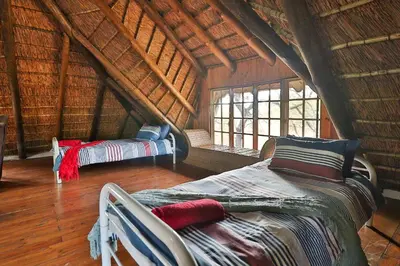 a room with two beds in a bamboo house at P.A.P.E's RETREAT in Marloth Park