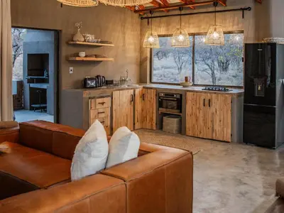 a living room with a couch and a kitchen at Minara Private Boutique Game Lodge in Dinokeng Game Reserve