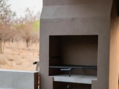 a stone fireplace with a tv in a wall at Minara Private Boutique Game Lodge in Dinokeng Game Reserve