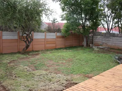a backyard with a fence and a table and chairs at Blesbok Inn in Polokwane