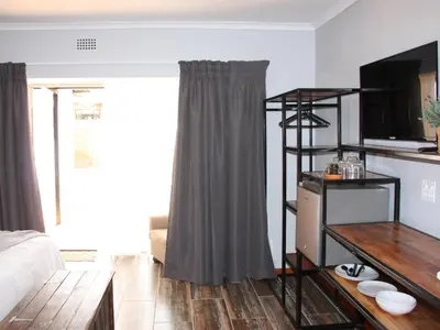 a living room with a couch and a television at Blesbok Inn in Polokwane