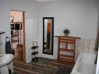 a bathroom with a tub and a sink and a mirror at Blesbok Inn in Polokwane