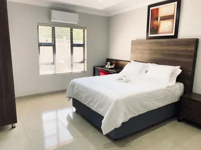 a bedroom with a large bed and a window at KB Guesthouse in Groblersdal