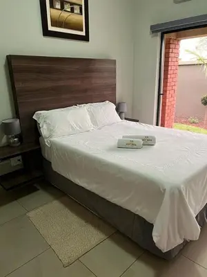 a bed with two trays on it in a bedroom at KB Guesthouse in Groblersdal