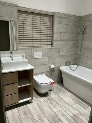 a bathroom with a sink and a tub and a toilet at KB Guesthouse in Groblersdal