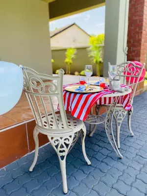 two chairs and a table with a red and white table cloth at KB Guesthouse in Groblersdal