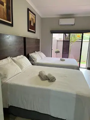 two beds in a hotel room with towels on them at KB Guesthouse in Groblersdal