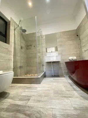 a bathroom with a shower and a tub and a sink at KB Guesthouse in Groblersdal