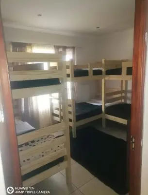 a room with four bunk beds in a room at Secunda BackPackers in Secunda