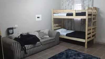 a living room with a couch and bunk beds at Secunda BackPackers in Secunda