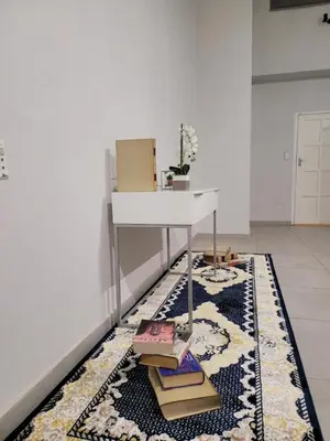 a room with a table and books on a rug at Falcon's Nest in Pretoria