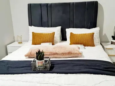 a bedroom with a large bed with a black headboard at Falcon's Nest in Pretoria