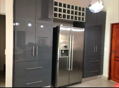 a stainless steel refrigerator in a kitchen with gray cabinets at Missie Villa 165 on Rooibok Euphoria Golf in Naboomspruit