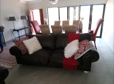 a brown couch with pillows on it in a living room at Missie Villa 165 on Rooibok Euphoria Golf in Naboomspruit
