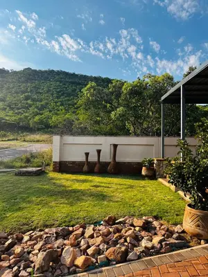 a backyard with a fence and a pile of rocks at Missie Villa 165 on Rooibok Euphoria Golf in Naboomspruit