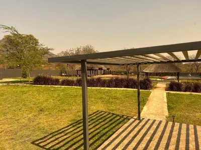 a bench with a shade in a park at CyC Guest Lodge in Giyani