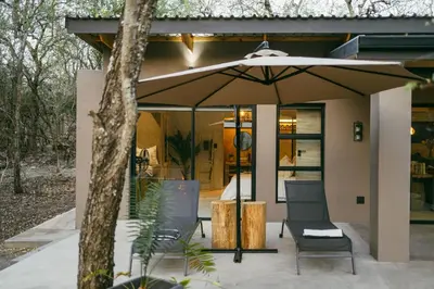 a patio with two chairs and an umbrella at Leopard's Khaya, Marloth Park in Marloth Park