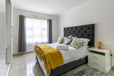 a bedroom with a large bed and a window at Signature Lodge in Kempton Park