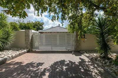 a driveway with a gate in front of a house at Signature Lodge in Kempton Park