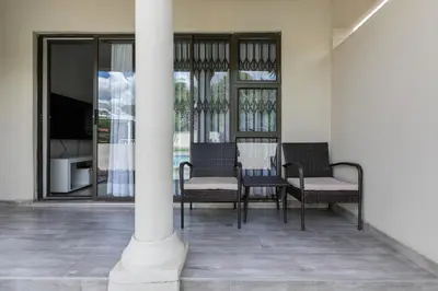 a porch with chairs and a column with a tv at Signature Lodge in Kempton Park