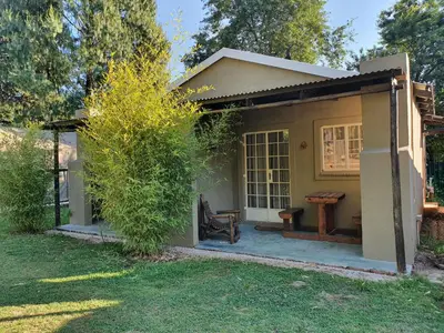 a small house with a bench in a yard at Stonefly Cottages in Dullstroom