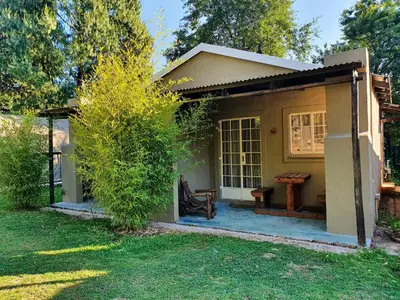 a small house with a bench in a yard at Stonefly Cottages in Dullstroom