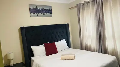 a bedroom with a large bed with a black headboard at Mall Of Africa Spot2 By Damo in Midrand