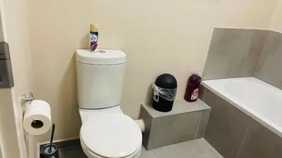 a bathroom with a white toilet and a bath tub at Mall Of Africa Spot2 By Damo in Midrand