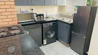 a kitchen with a washing machine and a sink at Mall Of Africa Spot2 By Damo in Midrand