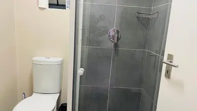 a bathroom with a shower with a toilet at Mall Of Africa Spot2 By Damo in Midrand