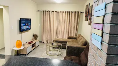 a living room with a couch and a tv at Mall Of Africa Spot3 By Damo in Midrand