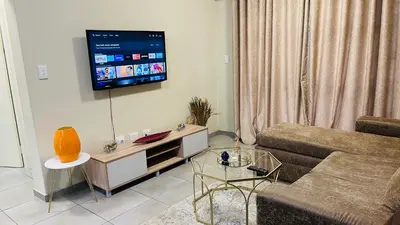 a living room with a couch and a flat screen tv at Mall Of Africa Spot3 By Damo in Midrand